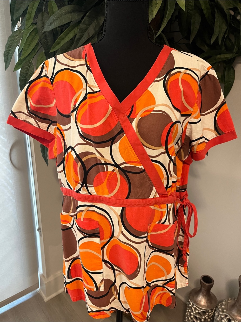 Koi Women's Wrap Scrub Top in Orange, Red & Brown Abstract Circles